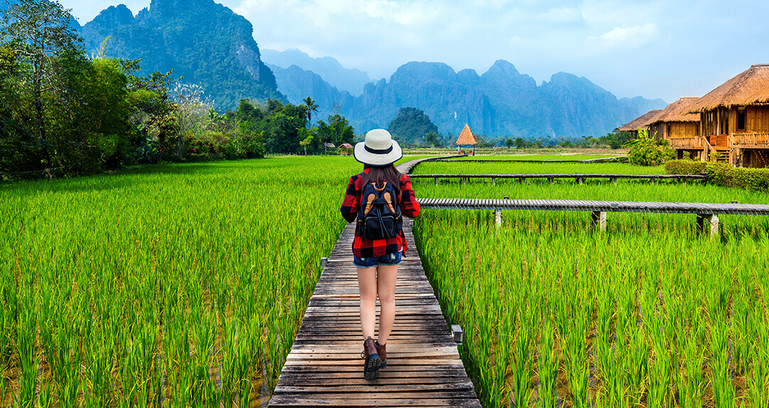 Tourism with backpack walking on wooden path, Vang vieng in Laos