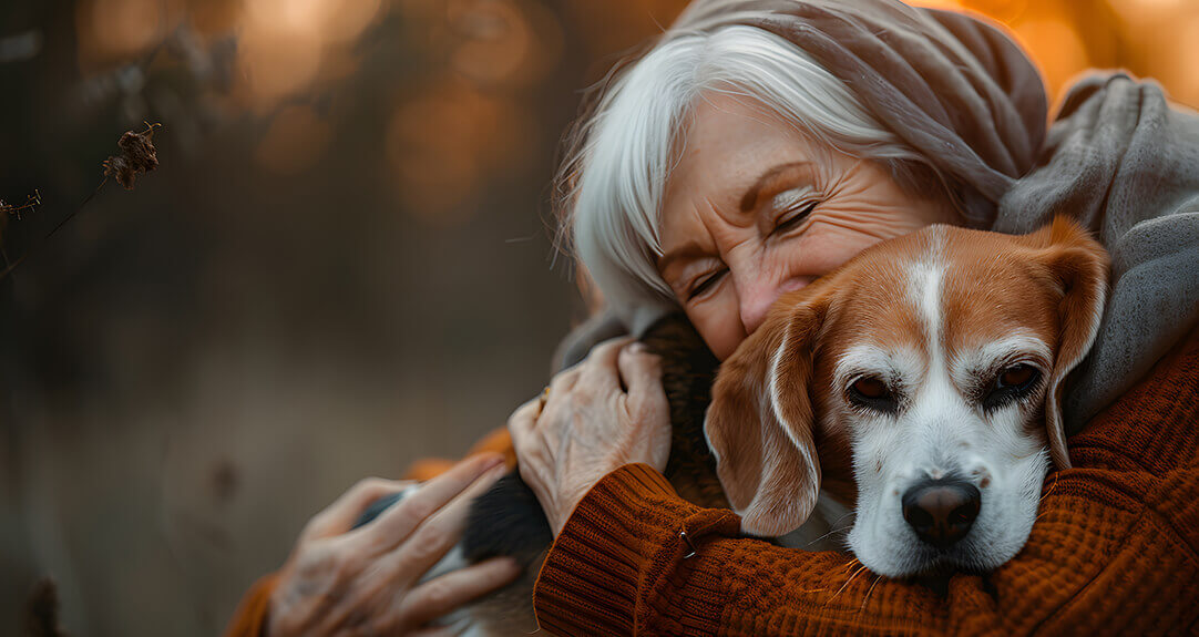 Retired senior woman with wrinkles smiling while embracing her beagle