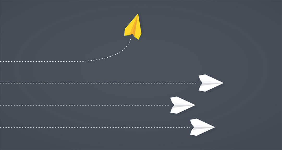 One yellow paper airplane flies upward while three white paper planes fly straight across a dark gray background.