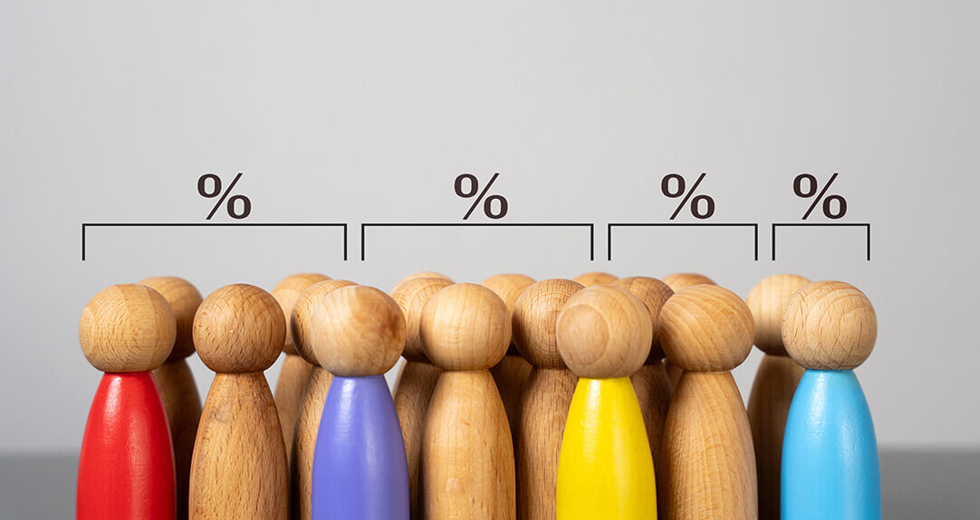 Rows of wooden peg figures stand with percentage figures and brackets over their heads, dividing them into groups.