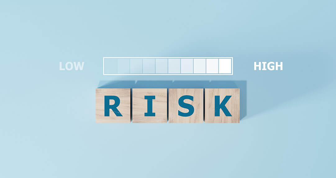 Wooden tiles spell out the word “risk” beneath a slider bar denoting low to high.