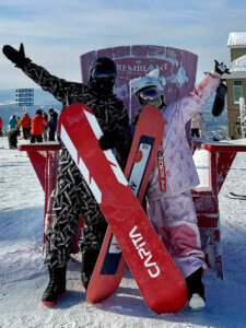 Ray and a companion pose with their snowboards.