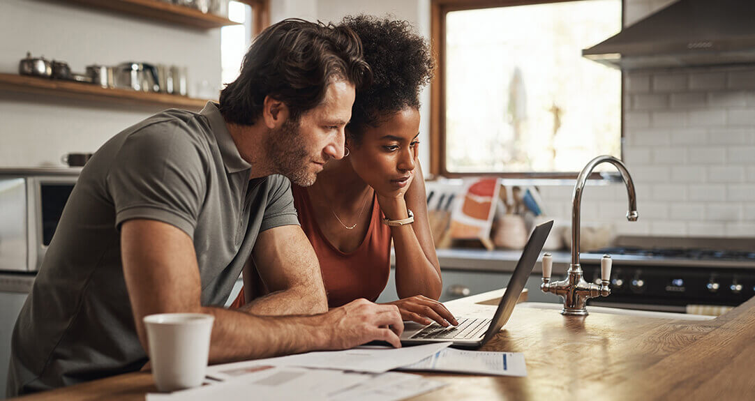 A couple studies files on a laptop in a homey kitchen.